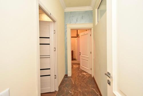 エレバンにあるGuest House Costaの白い壁の廊下とドアのある部屋