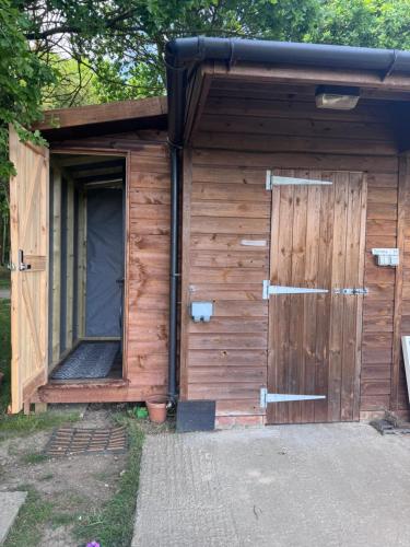 a wooden shed with a door and a window at The Skye Yurt in Messing