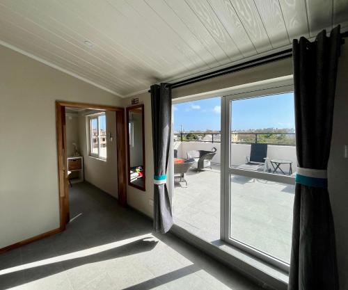 a room with a sliding glass door with a balcony at Rooftop d'exception - calme et confort à Grand Baie in Grand Baie