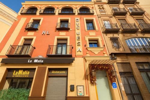 a tall building with a sign on the side of it at Hotel Duquesa in Seville