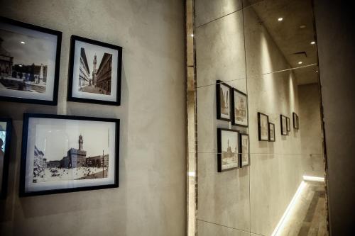 a wall with framed pictures on a wall at Benci House in Florence
