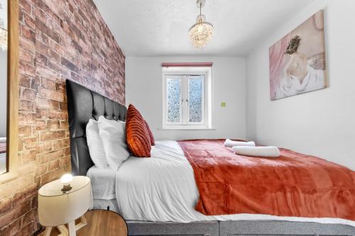 a bedroom with a large bed and a brick wall at Stunning 1 bedroom apartment in Dagenham in Dagenham