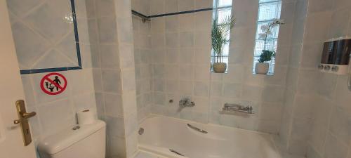 a white bathroom with a tub and a toilet at Harmony 5 in Áyios Spirídhon