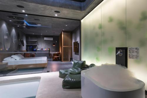 a living room with a bed and a couch and a room at Lush Motel Lapa in Sao Paulo