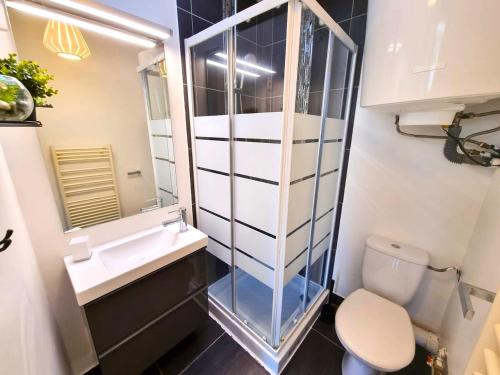 Un baño con lavabo, inodoro y espejo. en Studio Moderne Bien Pensé, en Elbeuf