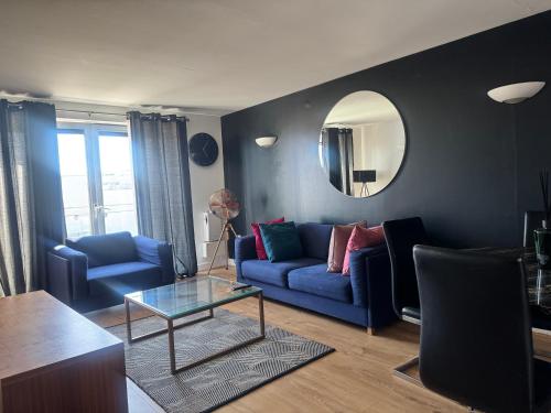 a living room with a blue couch and a mirror at LIME 2 Bedroom APARTMENT in North Woolwich