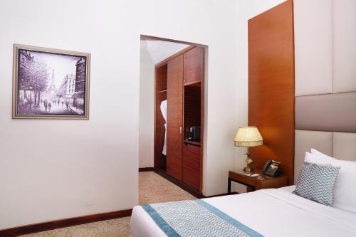 a hotel room with a bed and a mirror at Gewan Hotel Cairo in Cairo