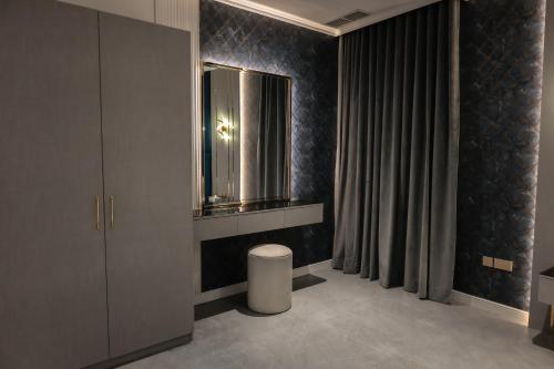 a bathroom with a mirror and a stool in it at Palazzo hotel in Kuwait