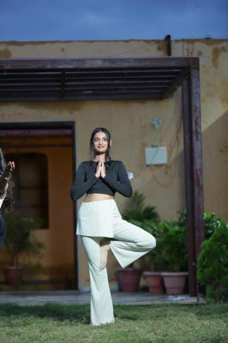a woman standing in the grass in front of a mirror at Mura Yoga Villa in Nauratori