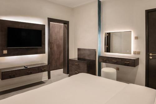 a bedroom with a bed and a tv and a mirror at Palazzo hotel in Kuwait