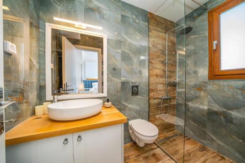 a bathroom with a sink and a toilet and a shower at Villa Drogarati Retreat by Villa Plus in Chaliotata