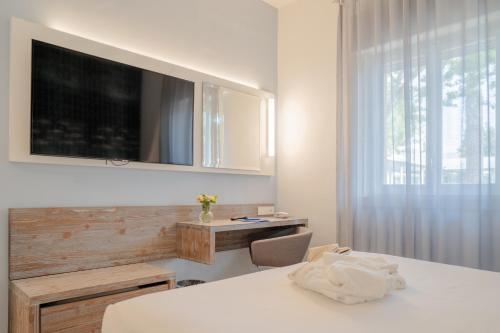 a bedroom with a desk and a television on a wall at Hotel Riva Del Sole in Giovinazzo