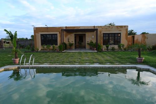a house with a swimming pool in front of it at Mura Yoga Villa in Nauratori