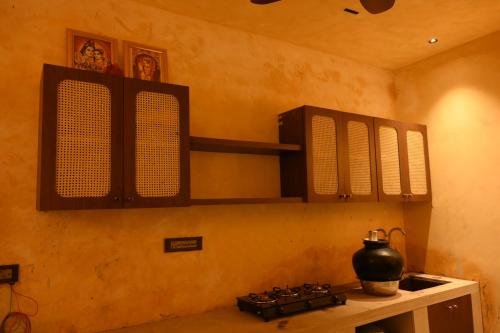 a kitchen with a stove and cabinets with a pot on it at Mura Yoga Villa in Nauratori