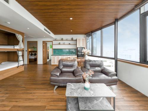 a living room with a couch and a table at Gold Central Hotel by Haviland in Da Nang