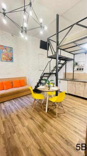 un salon avec un canapé, une table et des chaises dans l'établissement Смарт квартира в самому центрі міста, à Tchernivtsi