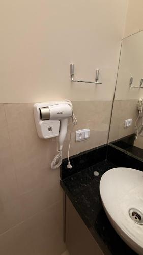 a bathroom with a toilet paper dispenser and a sink at Loma Sweet Home in Bataguaçu