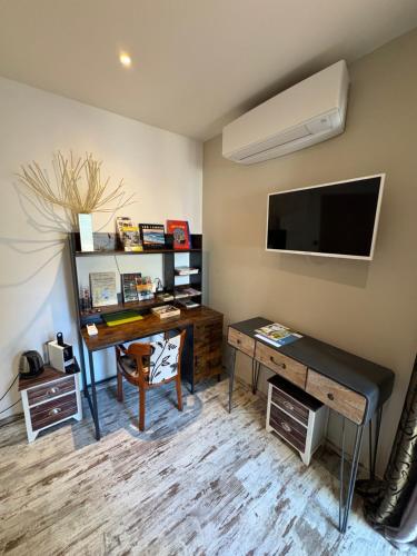a living room with a desk and a television at Chambres d'Hôtes Villa Aquitaine in Bretagne-de-Marsan