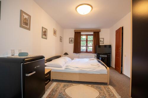 a small bedroom with a bed and a kitchen at Resort U Jelena in Křivoklát