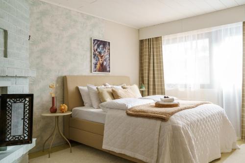 une chambre avec un lit avec des draps blancs et une cheminée dans l'établissement Reindeerly Cottage Hosted by Hygge Host, à Rovaniemi