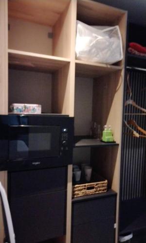 a kitchen with a black microwave in a room at Chambres d'Hôtes Villa Aquitaine in Bretagne-de-Marsan