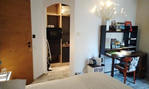 a bedroom with a bed and a desk with a telephone at Chambres d'Hôtes Villa Aquitaine in Bretagne-de-Marsan