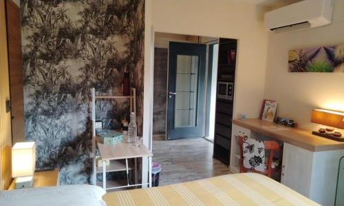 a room with a bedroom with a bed and a kitchen at Chambres d'Hôtes Villa Aquitaine in Bretagne-de-Marsan