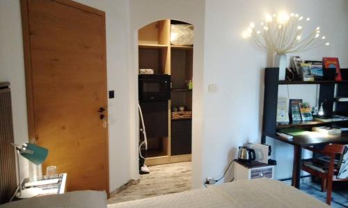 a room with a bed and a door and a desk at Chambres d'Hôtes Villa Aquitaine in Bretagne-de-Marsan