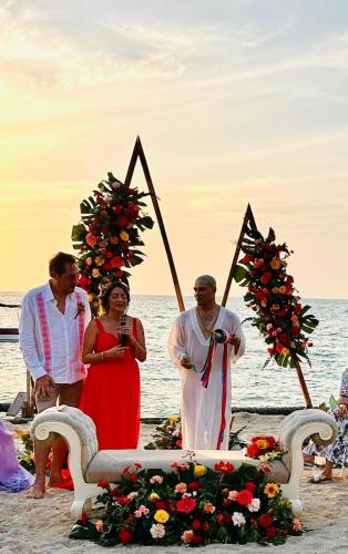 a group of people standing around a ceremony on the beach at Cristal Blue Barú in Baru