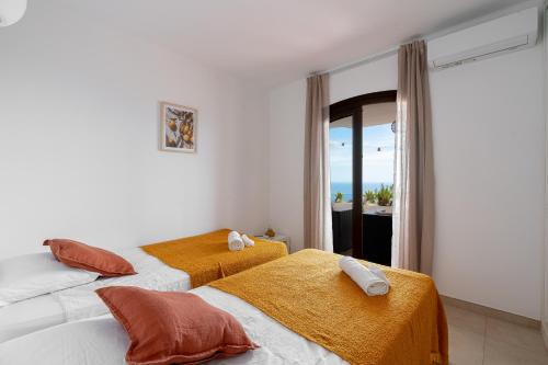 Dos camas en una habitación con vista al mar. en San Juan de Capistrano, 2 bedroom, en Nerja