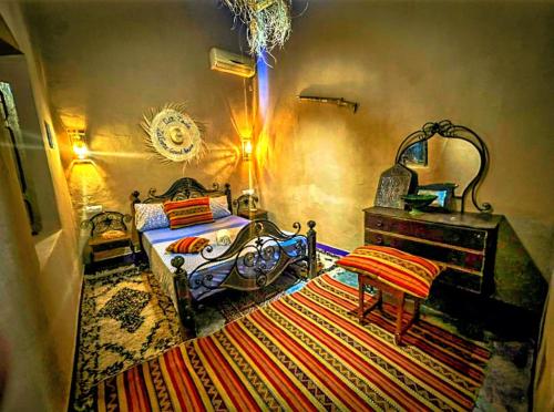 a bedroom with a bed and a dresser and a rug at Dar Toda - Zagora guest house in Zagora