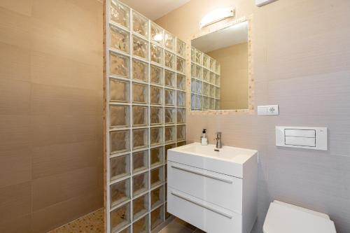 Un baño con lavabo, inodoro y espejo. en San Juan de Capistrano, 2 bedroom, en Nerja