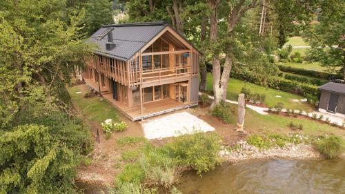 an overhead view of a wooden house next to a river at SeeZeit am Ossiacher See in Bodensdorf