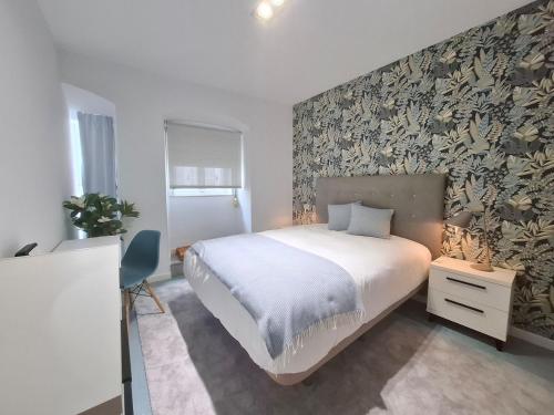 a bedroom with a large bed and a wall at O Enxido - Vive dentro de la muralla de Ribadavia in Ribadavia