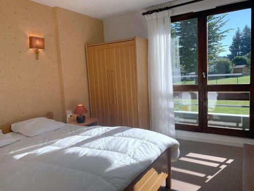 a bedroom with a bed and a large window at Appartement avec balcon exposé sud, 40 m², proche centre et pistes - Autrans, 6 pers. - FR-1-737-47 in Autrans