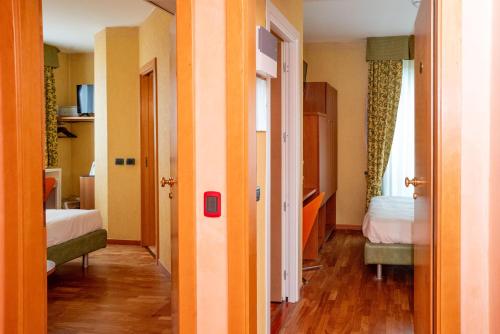 a room with two beds and a door to a bedroom at SIRIOHotel in Dormelletto