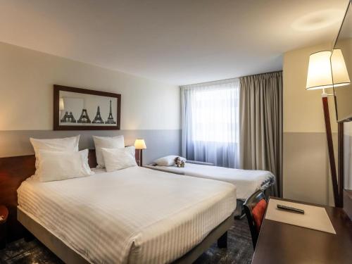 Ένα ή περισσότερα κρεβάτια σε δωμάτιο στο Mercure Paris Gare Montparnasse TGV