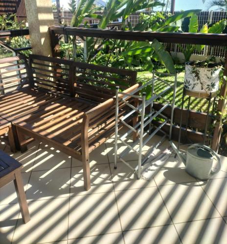 a wooden bench sitting on top of a balcony at Ylang Ylang in Saint-Leu