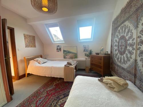 a bedroom with two beds and a dresser and two windows at The Barn - Wheatley - Oxford in Wheatley