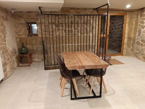 a dining room with a wooden table and chairs at Patio y Calados Rioja Suites in Cenicero