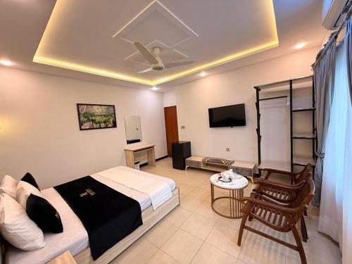 a hotel room with a bed and a tv at Nestopia Islamabad in Islamabad