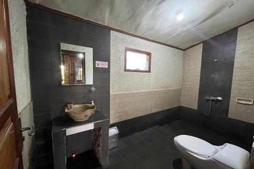 une salle de bain avec toilettes et lavabo dans l'établissement Tjapoeng Resort Pancawati, à Ciherangsating