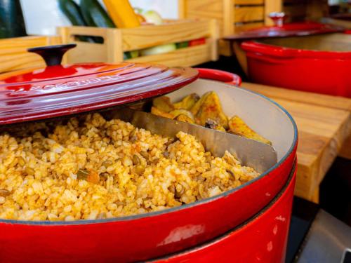 a red pot filled with fried food with a spatula at ibis budget Bogota Marly in Bogotá