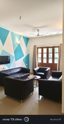 a living room with couches and a geometric wall at 2 bedroom apartment with pool in vagator in Jāmb