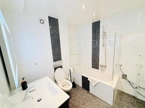 a white bathroom with a toilet and a sink at Ferienwohnung Hecker in Rastatt