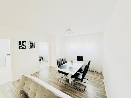 Un comedor blanco con una mesa y sillas. en Ferienwohnung Hecker, en Rastatt