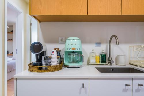a kitchen counter with a mixer and a sink at Zus House Stylish Pool Stay Near Lisbon & Beach in Parede