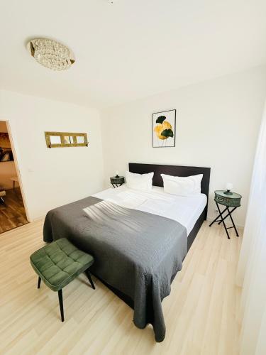 a bedroom with a large bed and a green chair at Ferienwohnung Hecker in Rastatt