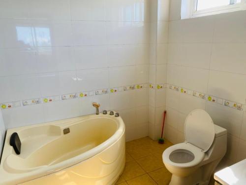 a bathroom with a bath tub and a toilet at Hakuna Matata Ocean View Home - Msasani Near Masaki in Dar es Salaam