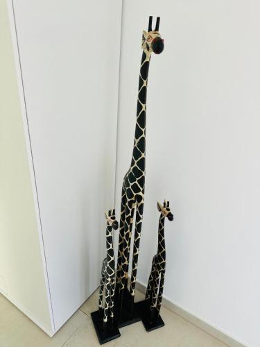 two giraffes are standing next to a wall at Große 2 Ferienwohnung Gästehaus NEUBAU Merzig 100 m2 in Merzig